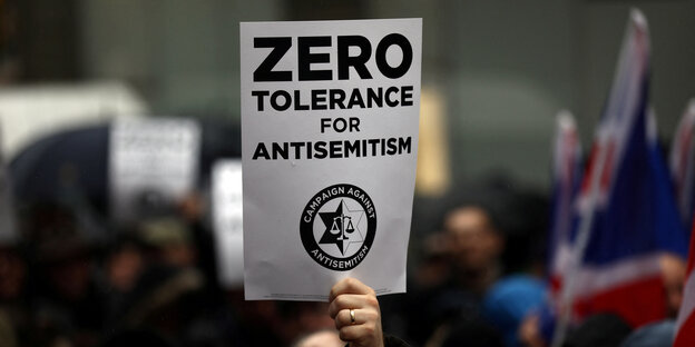 Ein Schild, auf dem steht "Zero Tolerance for Antisemitism", wird hochgehalten