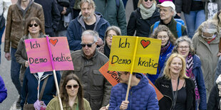 Zwei Demonstranten halten jeder ein SChild hoch auf dem steht: ich liebe Demokratie