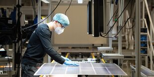 ein Arbeiter in einem Solarmodulwerk