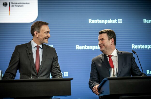 Finanzminister Lindner und Arbeitsminister Heil an zwei Redepulten, sie lächeln sich an