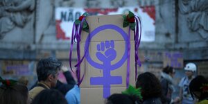 Auf einer Demo in Lissabon zum Frauentag wird ein Plakat hochgehalten mit kämpferischer Faust
