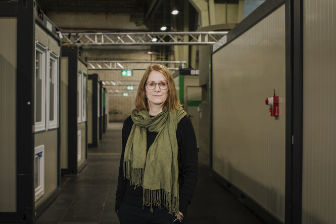 Porträtfoto Gunild Kiehn. Sie hat blonde Haare, trägt Brille und einen grünen Schal