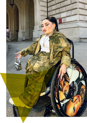 Melis Gedik im Rollstuhl mit Handtasche und einer Speichenschutze, auf der Tupac und Aaliyah abgebildet sind