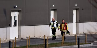 Feuerwehrleute an den Werkstoren der Tesla-Fabrik in grünheide