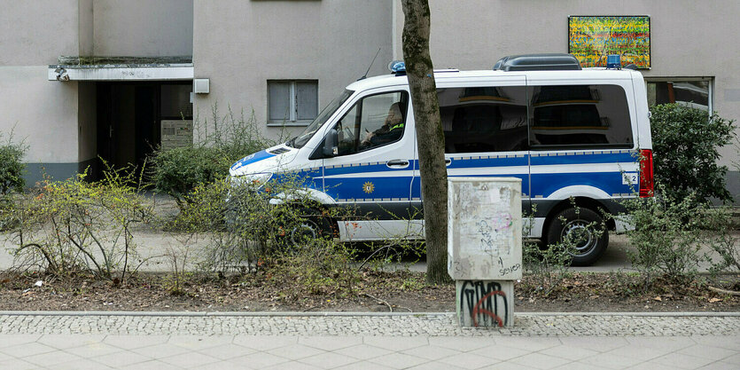 Ein Polizeiwagen steht vor einem Wohnhaus