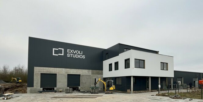 ein nicht ganz fertiger Zweckbau mit der Aufschrift "Exvoli Studios" unter norddeutsche-grauem Himmel