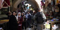 Stände mit Süßwaren und Taschen, Passanten und Polizisten in der Alstadt von Jerusalem. Alles ist sehr gedrängt.