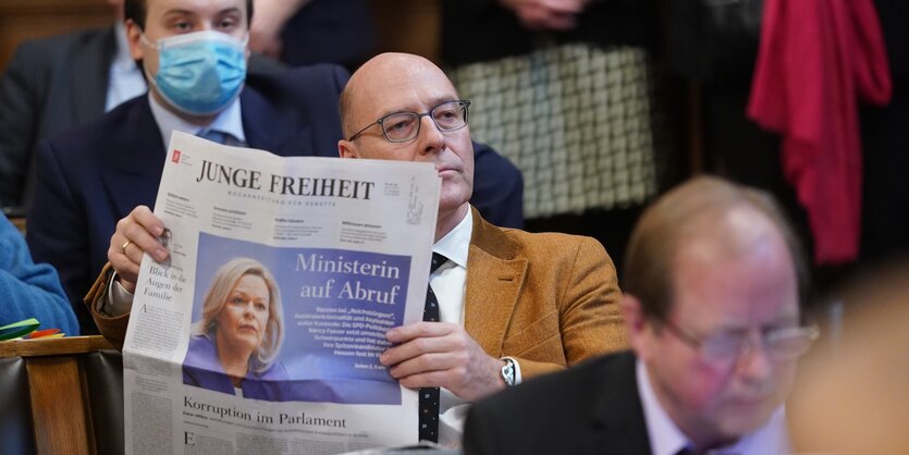 Ein Mann sitzt mit einer Ausgabe der Zeitung "Junge Freiheit" in der Hamburger Bürgerschaft