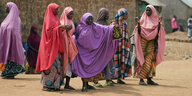 Junge Frauen in traditionellen Gewändern stehen zusammen auf der Straße
