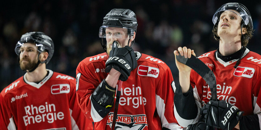 Drei Spieler der Kölner haie blicken ratlos drein