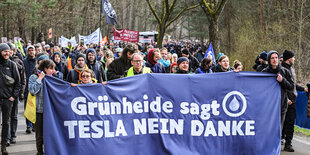 Bei einer Demonstration gegen die Tesla-Erweiterung unter dem Motto «Tesla Nein Danke!» tragen Teilnehmer ein Transparent.