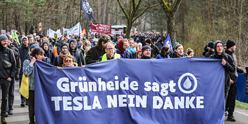 Bei einer Demonstration gegen die Tesla-Erweiterung unter dem Motto «Tesla Nein Danke!» tragen Teilnehmer ein Transparent.