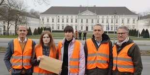 Mehrer Personen in Warnwesten vor dem Schloss Bellevue.