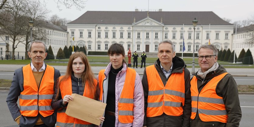 Mehrer Personen in Warnwesten vor dem Schloss Bellevue.