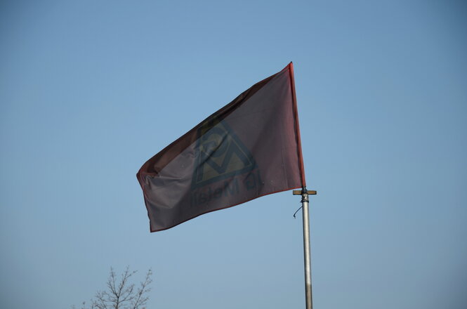 Die Flagge der IG Metall, die von den brennenden Ölfässern schon ganz schwarz ist