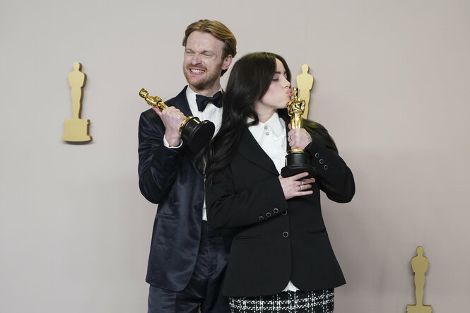 Finneas O'Connell (links) und Billie Eilish mit Oscar-Figuren