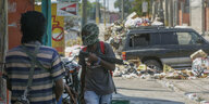 Bewaffnete Bandenmitglieder mit über den Kopf gezogenen Mützen an einer Straßensperre in Haitis Hauptstadt Port-au-Prince