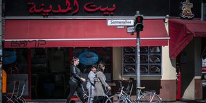 Die Sonnenallee - Eine Frau mit zwei Kindern und im Hintergrund ein arabisches Restaurant