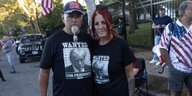 Zwei Menschen stehen Arm in Arm. Auf ihren T-shirts ist ein Bild von Trump.