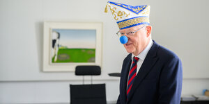 Ministerpräsident Stephan Weil in seinem Büro mit Karnevalsmütze und blauer Pappnase