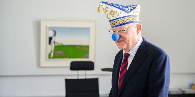 Ministerpräsident Stephan Weil in seinem Büro mit Karnevalsmütze und blauer Pappnase