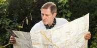 Andreas Dorau im Gebüsch mit Landkarte