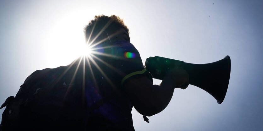 Silhouette einer Person, die ein megafon in der Hand hält