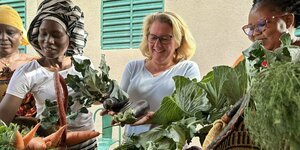 Eine Frau bestaunt Gemüse aus nachhaltigem Anbau.