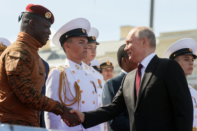 Präsident Wladimir Putin und der Interimspräsident von Burkina Faso, Ibrahim Traoré, schütteln sich vor Beginn einer großen Marineparade die Hände.