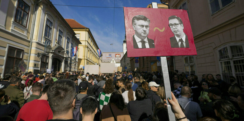 Eine Menschenmenge demonstriert, jemand hält ein Plakat mit den Gesichtern von Andrej Plenkovic und Aleksandar Vucic