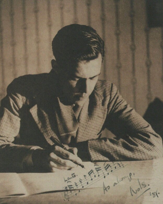 Auf einer alten Fotografie sitzt ein Mann am Schreibtisch