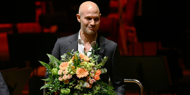 Omri Boehm mit Blumenstrauß bei der Preisverleihung am Mittwoch in Leipzig