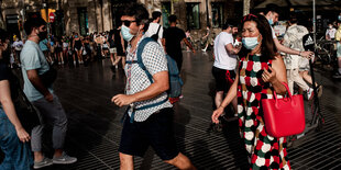 Menschen mit Masken auf der Rambla