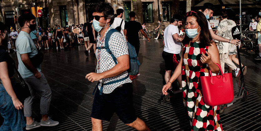 Menschen mit Masken auf der Rambla