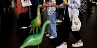 grüne Plastik-Dinos zwischen Messebesuchern