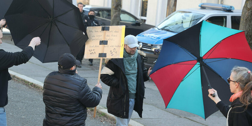 Ein AfD-­Lokalpolitiker filmt mit einem Smartphone Leute auf einer linken De­mons­tration