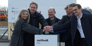 Veronika Wand-Danielsson (l-r), Schwedische Botschafterin in Deutschland, Daniel Günther, Bundeskanzler Olaf Scholz, Robert Habeck , Peter Carlsson, CEO von northvolt, und Christofer Haux, northvolt-Geschäftsführer, drücken gemeinsam den roten Knopf für den Start des Baus.