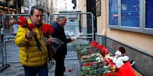 Zwei Männer legen Blumen vor dem russischen Konsulat in Istanbul nieder