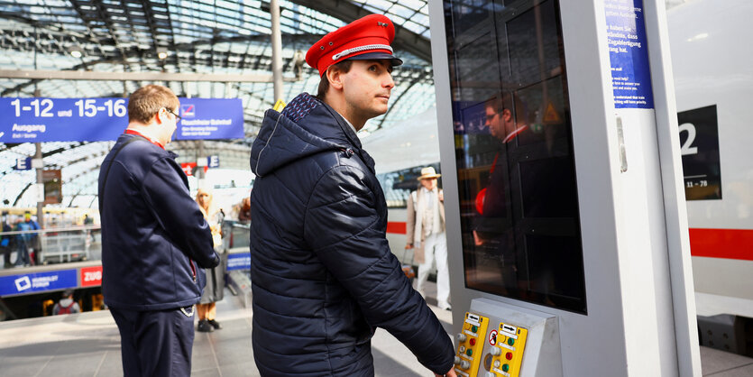 Ein Lokführer steht auf dem Bahnsteig