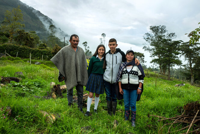 Guillermo Juan Martinez steht mit seiner Familie, dem Vater seiner Schwester und der Mutter auf einer grünen Wiese, im Hintergrund eine nebelverhangene hügelige Landschaft