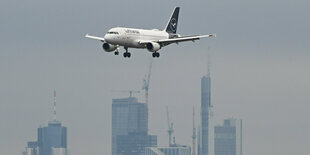 Ein Passagierflugzeug der Lufthansa ist vor der Frankfurter Skyline im Landeanflug auf den Frankfurter Flughafen