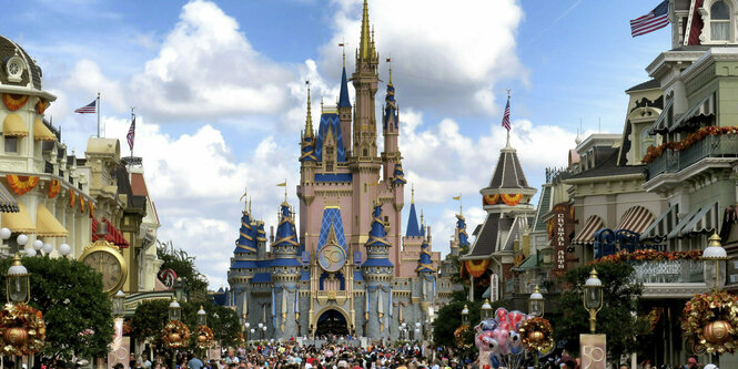 Eine Menschenmenge füllt die Straße vor einem Schloss in Disney World