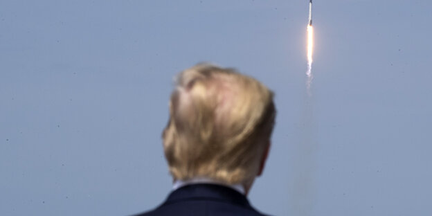 Trump blickt auf einen Raketenstart.