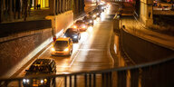 Autos fahren bei Nacht mit Scheinwerfen über eine Straße