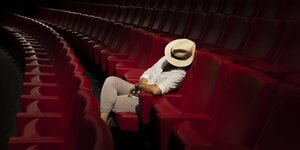 Frau mit Hut schläft allein im Kino