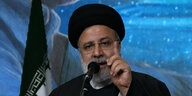 Irans Präsident Raisi spricht in ein Mikrofon