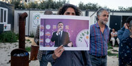 Eine Person hält ein Plakat in die Höhe, welches den kurdischen Politiker Abdullah Zeydan zeigt.