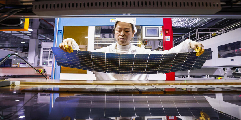 Ein Arbeiter stellt Teile für ein Solarpanel her