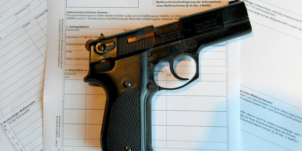 Eine Pistole liegt auf einem Antrag für die Ausstellung eines Waffenscheines.