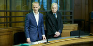 Zwei Männer stehen in einem Gerichtssaal.